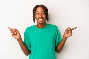 Beyaz arka planda izole edilmiş genç Afro-Amerikalı adam farklı kopya alanlarını gösteriyor, birini seçiyor, parmaklarıyla gösteriyor..