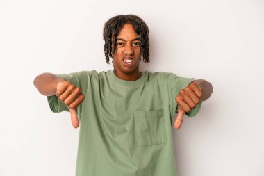 Beyaz arka planda izole edilmiş genç Afro-Amerikalı adam baş parmağını aşağı gösteriyor ve hoşlanmadığını ifade ediyor..