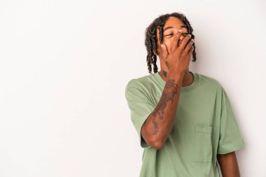 Genç Afro-Amerikan erkeği beyaz arka planda izole edilmiş mutlu, kaygısız, doğal duygulara gülüyor..