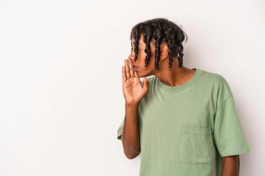 Beyaz arka planda izole edilmiş genç Afro-Amerikan bir adam gizli bir sıcak fren haberi veriyor ve kenara bakıyor.