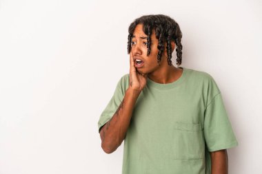 Genç Afro-Amerikalı bir adam beyaz arka planda izole edilmiş, gördüğü bir şey yüzünden şoka uğruyor..