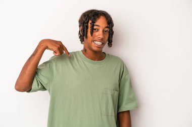 Genç Afro-Amerikan adam beyaz arka planda izole edilmiş. Elle bir gömlek fotokopi alanını gösteriyor. Gururlu ve kendinden emin.