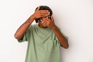 Genç Afrikalı Amerikalı adam beyaz arka planda izole edilmiş. Kameraya parmaklarıyla göz kırpıyor. Yüzünü kapatmaktan utanıyor..