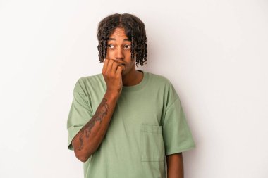 Genç Afrikalı Amerikalı bir adam beyaz arka planda izole edilmiş tırnak yiyor, gergin ve endişeli..