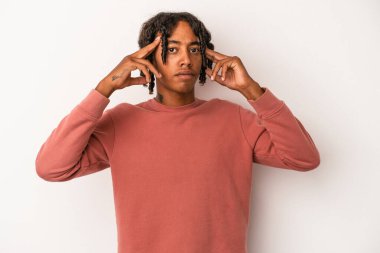 Beyaz arka planda izole edilmiş genç Afrikalı Amerikalı bir adam bir göreve odaklanmış, işaret parmaklarını işaret ediyor..