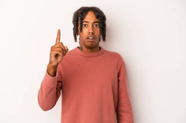 Beyaz arka planda izole edilmiş genç Afro-Amerikalı adam ağzı açık bir şekilde üst tarafı işaret ediyor..