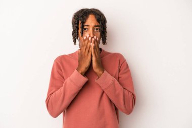 Beyaz arka planda izole edilmiş genç Afrikalı Amerikalı adam elleriyle ağzını kapatırken şok oldu..