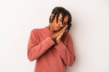 Beyaz arka planda izole edilmiş genç Afrikalı Amerikalı adam esniyor. Ağzını eliyle kapatan yorgun bir hareket sergiliyor..