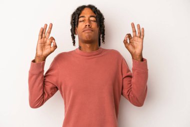Genç Afrikalı Amerikalı erkek, beyaz arka planda izole edilmiş yoğun bir günün ardından dinleniyor, yoga yapıyor..
