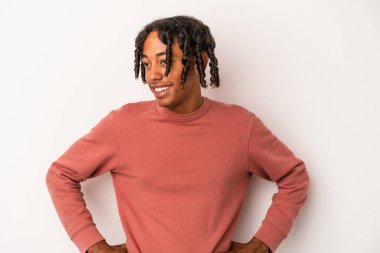 Genç Afro-Amerikalı adam beyaz arka planda izole edilmiş. Kendine güvenen, kalçaları tutan..