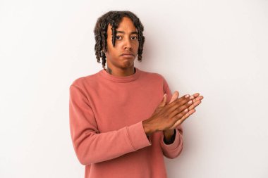 Genç Afrikalı Amerikalı adam beyaz arka planda izole edilmiş enerjik ve rahat hissediyor, kendinden emin ellerini ovuşturuyor..