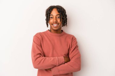 Beyaz arka planda izole edilmiş genç bir Afrikalı Amerikalı. Kendine güveniyor, kararlılıkla kollarını kavuşturuyor..