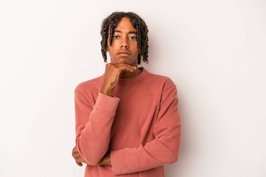 Genç Afrikalı Amerikalı adam beyaz arka planda izole edilmiş şüpheli, belirsiz, seni inceliyor..