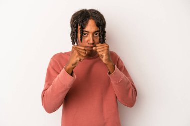 Beyaz arka planda izole edilmiş genç Afro-Amerikan adam kameraya yumruğunu gösteriyor, agresif yüz ifadesi..