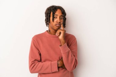 Beyaz arka planda izole edilmiş genç Afrikalı Amerikalı adam alaycı bir ifadeyle kameraya bakıyor..