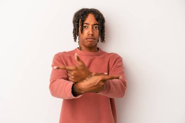 Beyaz arka plan noktalarında izole edilmiş genç Afrikalı Amerikalı iki seçenek arasında seçim yapmaya çalışıyor..