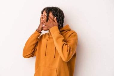 Genç Afrikalı Amerikalı, beyaz arka planda izole edilmiş. Gözleri elleriyle kapatmaktan korkuyor..