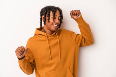 Beyaz arka planda izole edilmiş genç Afrikalı Amerikalı özel bir günü kutluyor, atlıyor ve enerjiyle kollarını kaldırıyor..