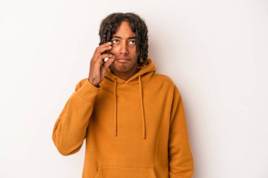 Genç Afrikalı Amerikalı adam beyaz arka planda izole edilmiş, parmakları dudaklarında bir sır saklıyor..