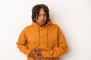 Beyaz arka planda karaciğer ağrısı ve karın ağrısı çeken genç bir Afrikalı Amerikalı..