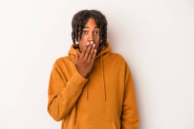 Beyaz arka planda izole edilmiş genç Afrikalı Amerikalı adam şok olmuş, ağzı ellerle kaplanmış, yeni bir şey keşfetmeye hevesli..