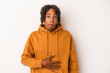 Beyaz arka planda izole edilmiş genç Afrikalı Amerikalı adam karnına dokunuyor, nazikçe gülümsüyor, yemek yiyor ve tatmin oluyor..