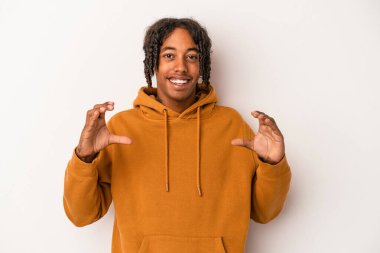 Beyaz arka planda izole edilmiş genç Afro-Amerikan bir adam elinde avuç içi bir şeyle kameraya teklif ediyor..