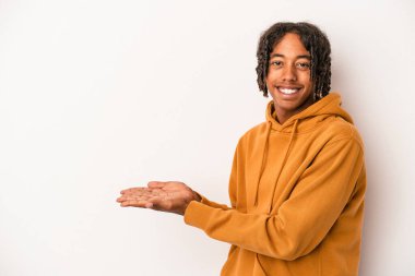 Beyaz arka planda izole edilmiş genç Afro-Amerikalı bir adam bir palmiye üzerinde bir kopya alanı tutuyor..