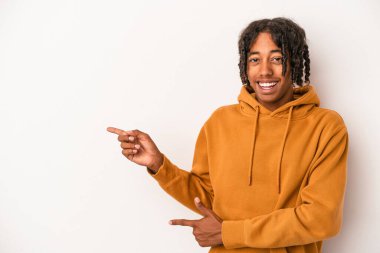 Beyaz arka planda izole edilmiş genç Afro-Amerikalı adam işaret parmağıyla işaret ettiği için heyecanlı..