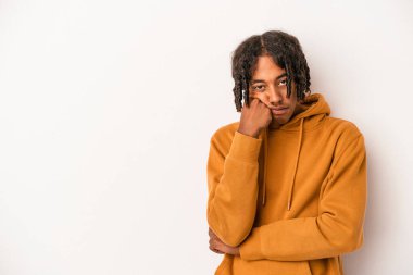 Beyaz arka planda izole edilmiş genç Afrikalı Amerikalı üzgün ve dalgın bir şekilde fotokopi odasına bakıyor..