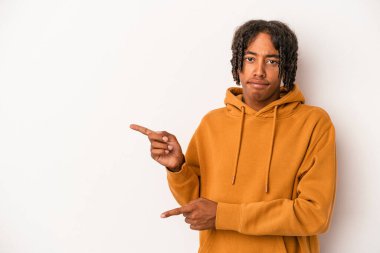 Beyaz arka planda izole edilmiş genç Afrikalı Amerikalı adam işaret parmağıyla fotokopi alanını işaret ederek şok oldu..