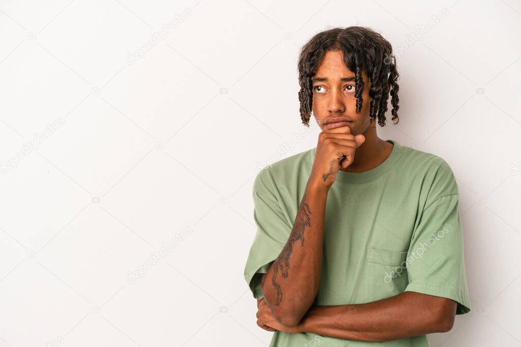 Young african american man isolated on white background relaxed thinking about something looking at a copy space.