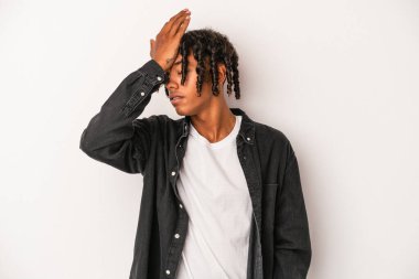 Beyaz arka planda izole edilmiş genç Afro-Amerikan bir şeyi unutuyor. Alnına avuç içi ve kapalı gözlerle vuruyor..