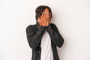 Genç Afrikalı Amerikalı adam beyaz arka planda izole edilmiş. Kameraya parmaklarıyla göz kırpıyor. Yüzünü kapatmaktan utanıyor..