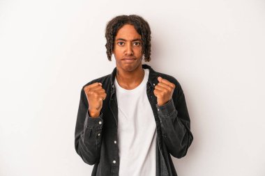 Beyaz arka planda izole edilmiş genç Afro-Amerikan adam kameraya yumruğunu gösteriyor, agresif yüz ifadesi..
