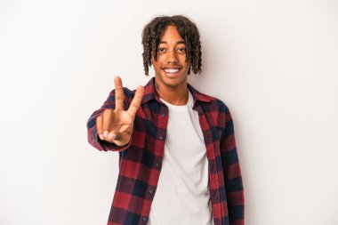 Genç Afrikalı Amerikalı adam beyaz arka planda izole edilmiş neşeli ve kaygısız parmaklarıyla barış sembolü gösteriyor..