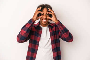 Beyaz arka planda izole edilmiş genç Afro-Amerikan bir başarı fırsatı bulmak için gözlerini açık tutuyor..