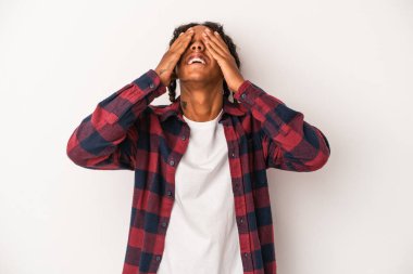 Beyaz arka planda izole edilmiş genç Afro-Amerikalı adam mutlu bir şekilde ellerini başının üstünde tutarak gülüyor. Mutluluk kavramı.