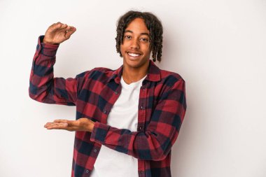 Genç Afro-Amerikalı adam beyaz arka planda izole edilmiş. Elinde parmakları olan, gülümseyen ve kendinden emin bir şey var..