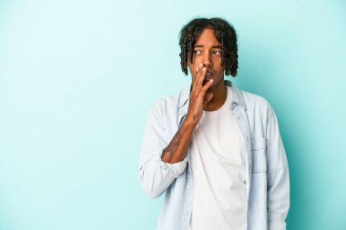 Mavi arka planda izole edilmiş genç Afro-Amerikan bir adam gizli bir sıcak fren haberi söylüyor.