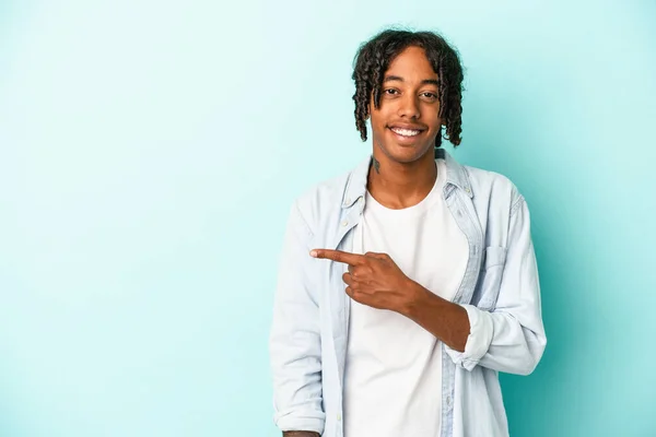 Joven Afroamericano Aislado Sobre Fondo Azul Sonriendo Señalando Lado Mostrando —  Fotos de Stock