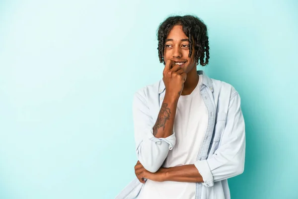 Junger Afrikanisch Amerikanischer Mann Isoliert Auf Blauem Hintergrund Denkt Entspannt — Stockfoto