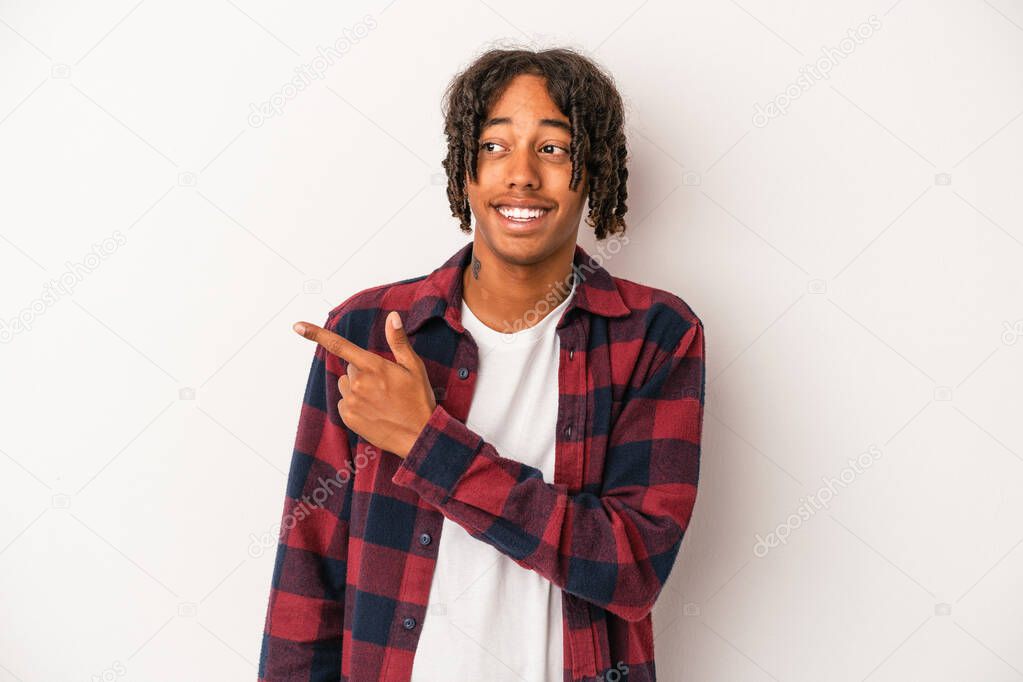 Young african american man isolated on white background looks aside smiling, cheerful and pleasant.