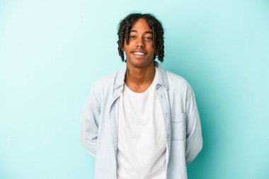 Genç Afrikalı Amerikalı adam mavi arka planda izole edilmiş mutlu, güler yüzlü ve neşeli..