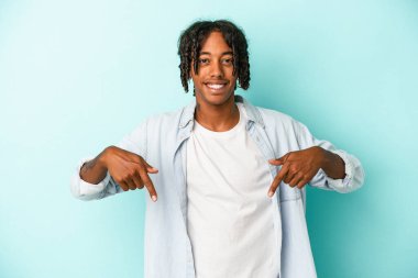 Genç Afrikalı Amerikalı adam mavi arka planda izole edilmiş. Parmakları aşağıda..