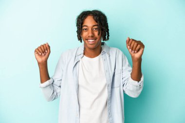 Genç Afrikalı Amerikalı adam mavi arka planda izole edilmiş dans ediyor ve eğleniyor..