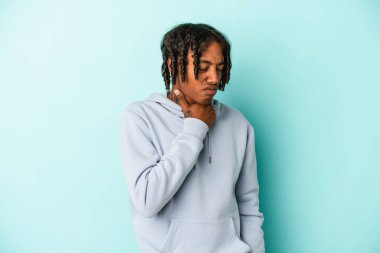 Mavi arka planda izole edilmiş genç Afrikalı Amerikalı bir adam virüs ya da enfeksiyon yüzünden boğazında acı çekiyor..