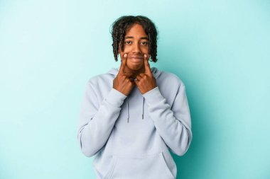 Genç Afro-Amerikalı iki seçenek arasında kuşkuyla mavi arka planda izole edilmiş..