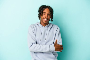 Genç Afrikalı Amerikalı adam mavi arka planda izole edilmiş gülüyor ve eğleniyor..