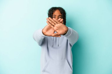 Genç Afrikalı Amerikalı adam mavi arka planda izole edilmiş bir şekilde inkar jesti yapıyor.